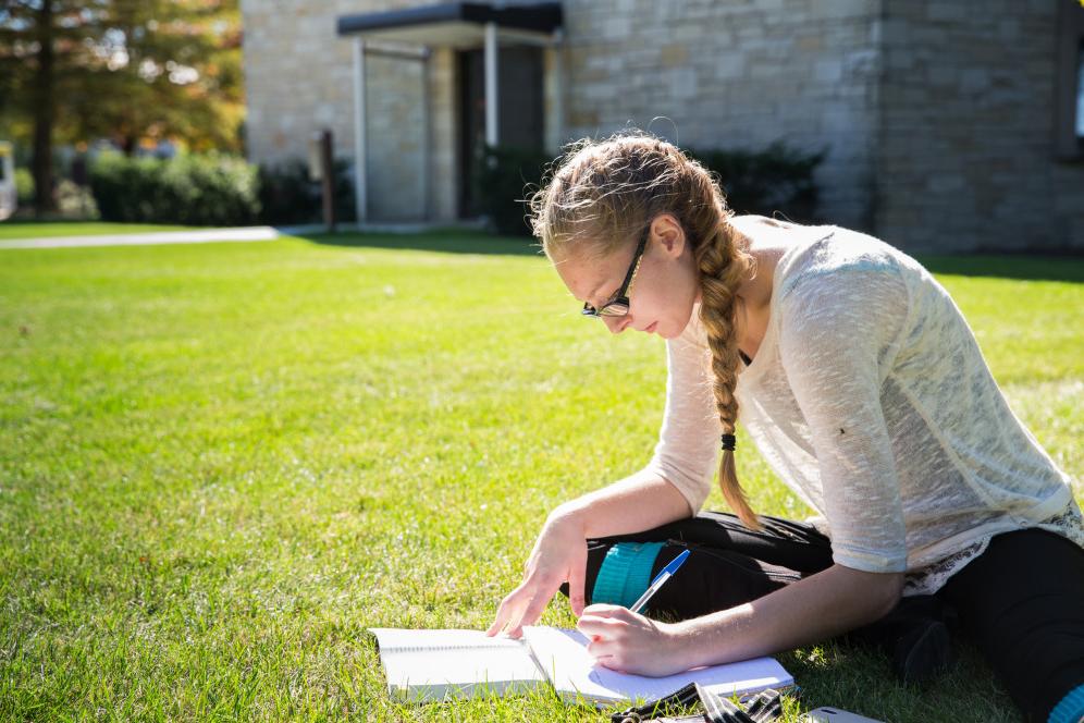 A student studies outside. Being an office writer is one of many student employment opportunities...